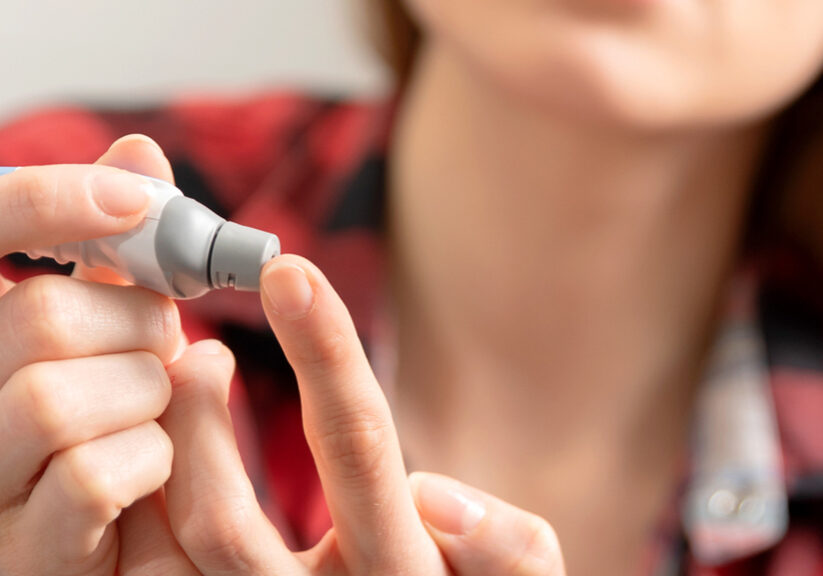 Young woman measures blood sugar level.