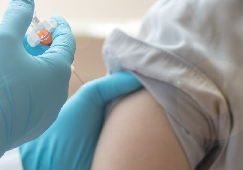 World immunization week and International HPV awareness day concept. Woman having vaccination for influenza or flu shot or HPV prevention with syringe by nurse or medical officer.