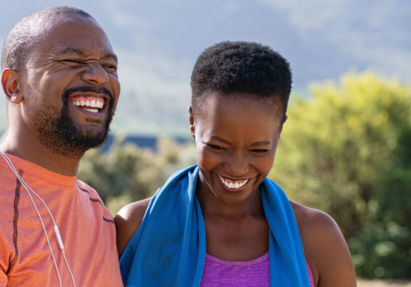 African fitness mature couple laughing at park