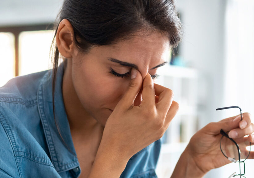 Stressed business woman working from home on laptop looking worried, tired and overwhelmed.